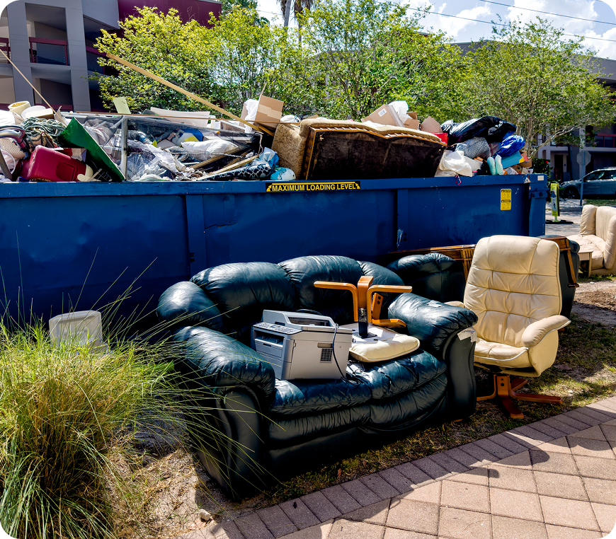 Discarded furniture and electronics by dumpster