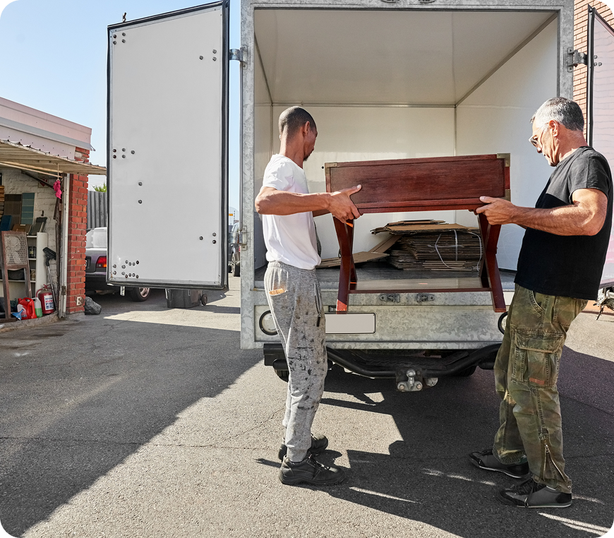 Two movers carrying a wooden table